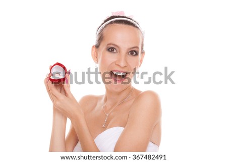 Excited happy bride holding opening engagement ring box. Surprised woman in white wedding dress isolated on white background.