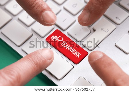 Computer Keyboard Concept: Many fingers pushing red TEAMWORK keyboard button