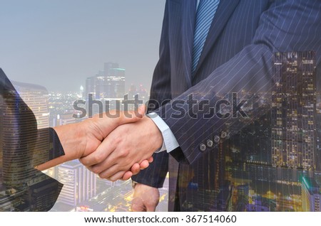 Double exposure handshake between businessman on cityscape background, Business concept