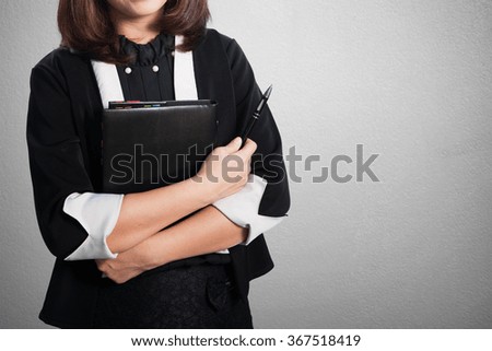 Asia Business woman holding notebook and pen on blank wall for text and background.Copy Space