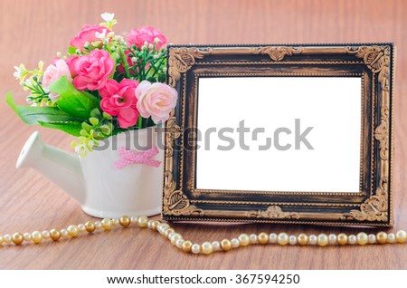 Blank vintage photo frame with flower in wooden room. Save clipping path.
