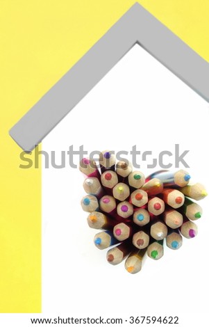 A Lot Of Sharped Colored Pencils Are Sticking Out From The Heart Shaped Window In The Home White Wall Isolated On Yellow Background, Vertical Image