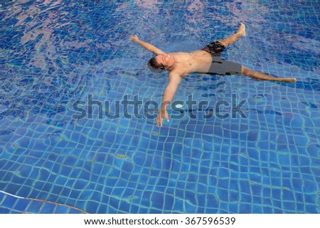 Thai man swimming in the pool