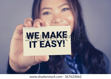 WE MAKE IT EASY ! message on the card shown by a businesswoman