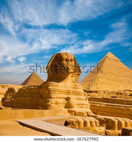 Full profile of Great Sphinx including pyramids of Menkaure and Khafre in the background on a clear sunny, blue sky day in Giza, Cairo, Egypt with no people Royalty-Free Stock Photo #367627982
