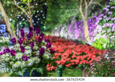 blur image of restaurant and flower in the garden night time for background usage.in-Thailand