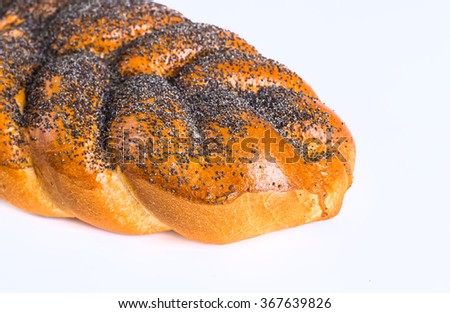 Two whole fresh challah bread with poppy and sesame seeds on a white background