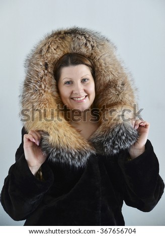 A woman in a fur coat on a light background