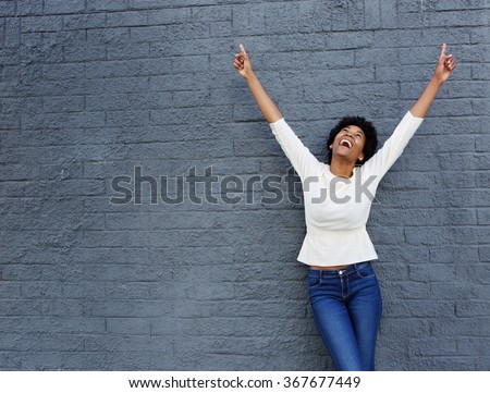 Portrait of a cheerful african woman with hands raised pointing up Royalty-Free Stock Photo #367677449