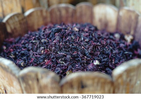 Dried hibiscus in a wooden barrel with very shallow depth of field