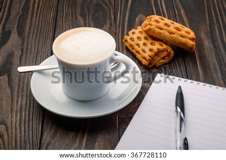 Cup Coffee and Note Pad on old wood background