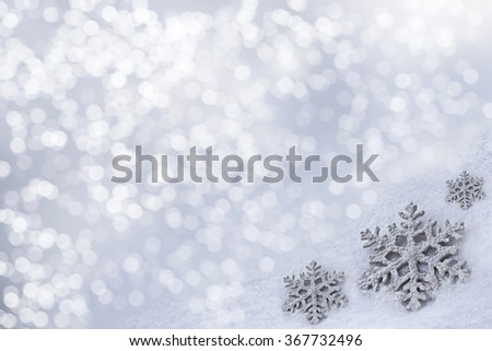 Glass toy snowflake on snow background. New Year card.