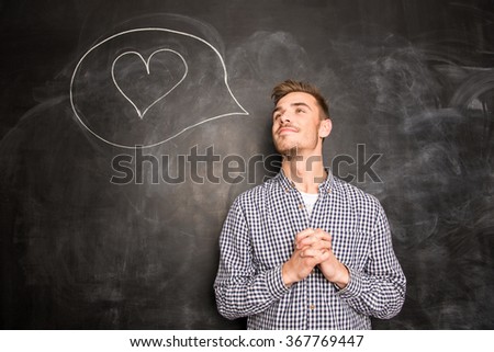 Portrait of dreaming guy to fall in love on black chalkboard