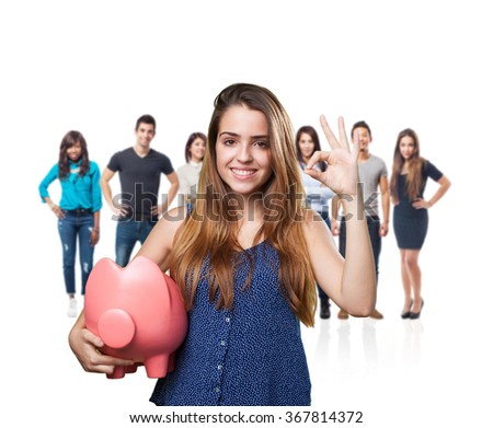 young cute woman doing okay gesture holding a piggy bank