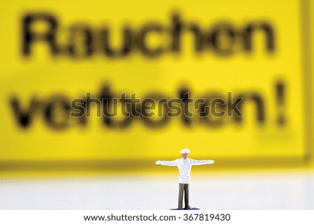 Figurine standing in front of no smoking sign board