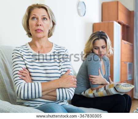 Portrait of offended mature woman and displeased young girl quarrelling Royalty-Free Stock Photo #367830305