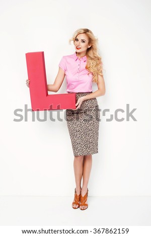 Beautiful blonde woman holding e letter, sing love. Fashion valentines day photo