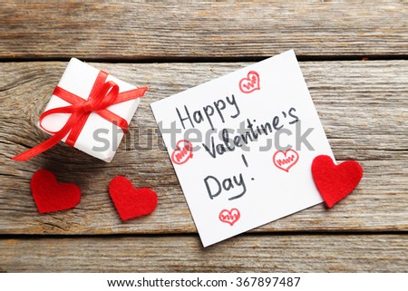 Red heart and sheet of paper on a grey wooden table