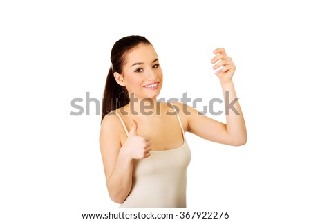 Woman with anti perspirant and thumbs up.