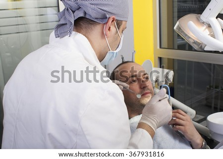 Young  man having his teeth examined by dentist