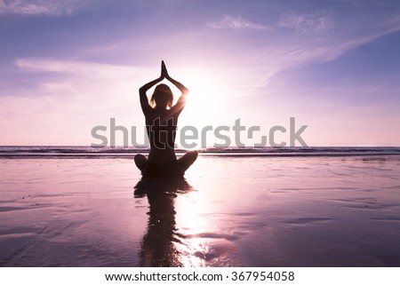 Female practicing morning yoga exercises on a beach for healing Royalty-Free Stock Photo #367954058