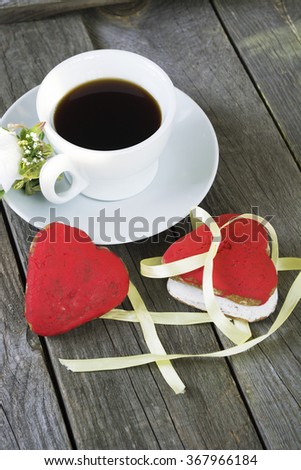 Romantic breakfast on Valentine's Day. Cup of coffee and heart shape cookies, white rose decoration. Toned image