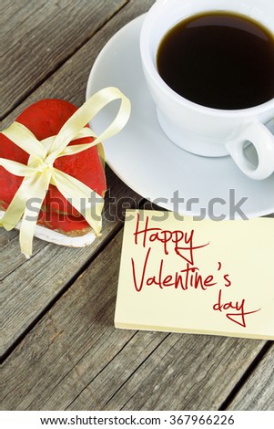 Romantic breakfast on Valentine's Day. Cup of coffee and heart shape cookies, white rose decoration, Happy Valentine's Day message. Toned image
