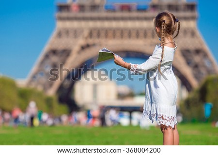 Adorable little girl with map of Paris background the Eiffel tower
