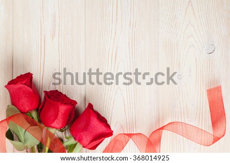 Red roses on wooden background. Valentines day background