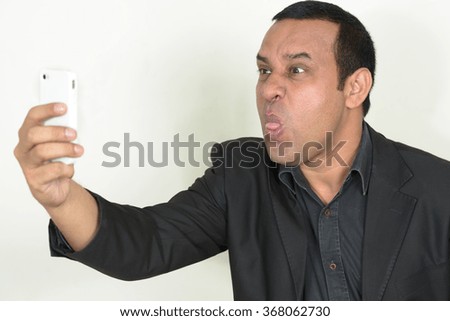 Indian businessman taking selfie picture with mobile phone