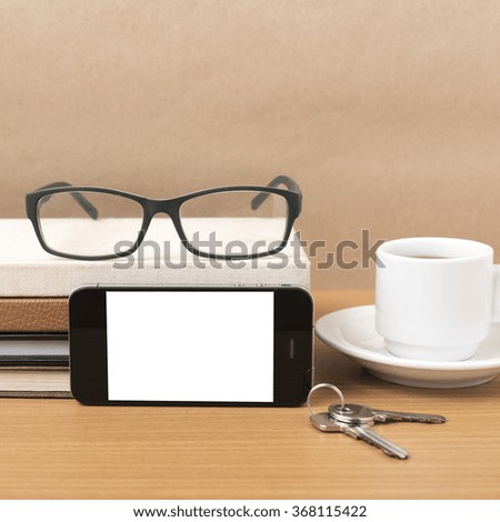 coffee,phone,key,eyeglasses and stack of book on wood table background