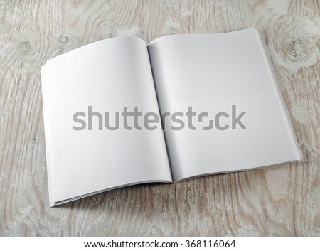 Photo of blank opened brochure on light wooden background. Template for graphic designers portfolios. Top view.