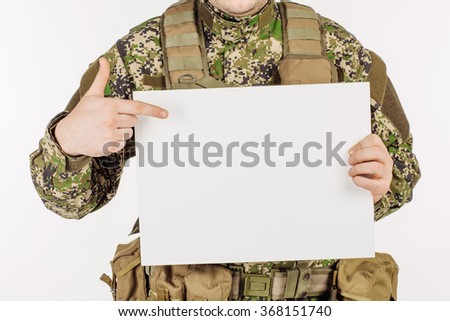 Portrait of a soldier holding white sheet of paper against white background