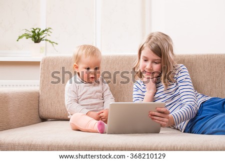 Two sisters watching tablet PC