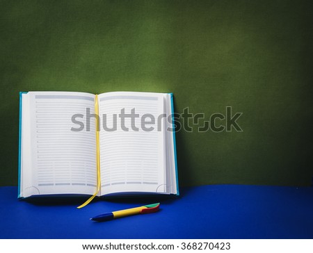 Diary on green background. Focus on page.
