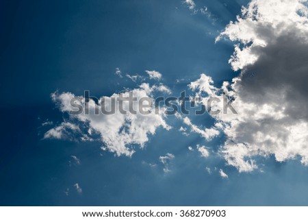 Sun beam with fluffy white clouds