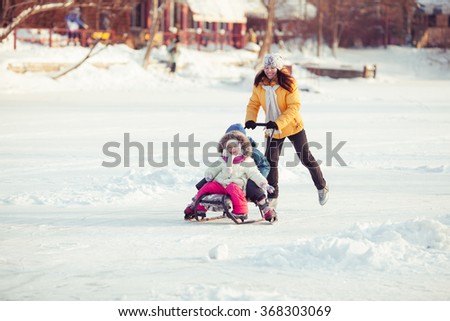 Family walking in a winter park. Child on sled