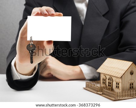 Real estate concept. Hands holding blank business card with keys. 