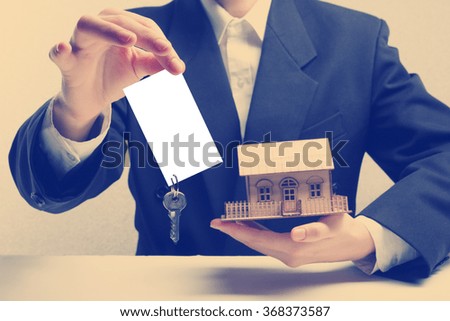 Real estate concept. Hands holding blank business card with keys. 