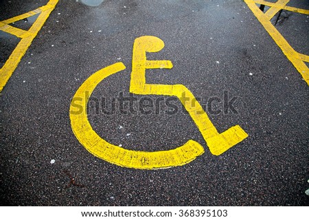 Yellow disable parking road sign marking on tarmac