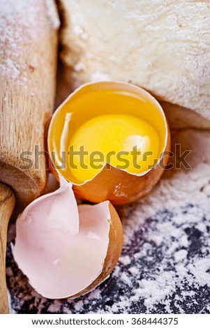 Baking background with eggshell, flour and rolling pin. Pizza cooking ingredients. Selective focus.