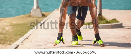 Focused young male athlete outdoors looking at camera. 