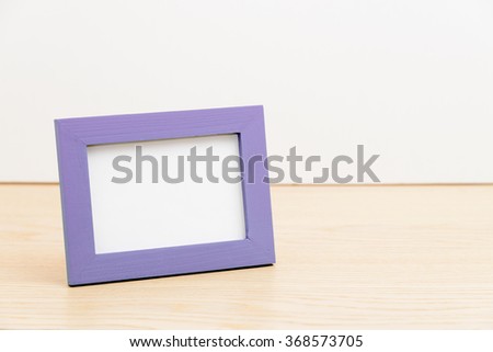 purple photo frame on wooden table white background