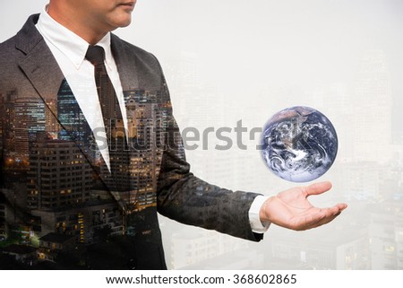 Business Man Holding Earth globe double exposure with building. Elements of this image furnished by NASA