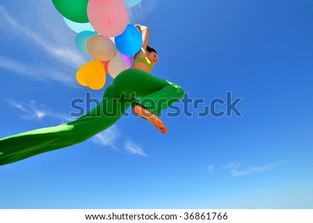 girl with colorful balloons jumping and the blue sky