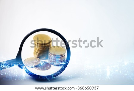 Double exposure of city and the magnifying glass focus at rows of coins for finance and banking concept