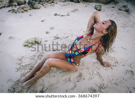 Beautiful woman lying and posing on the beach