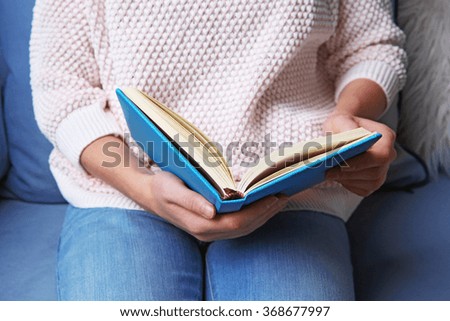 Woman  reading book at home, close up 