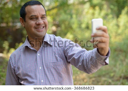 Indian man in park taking selfie