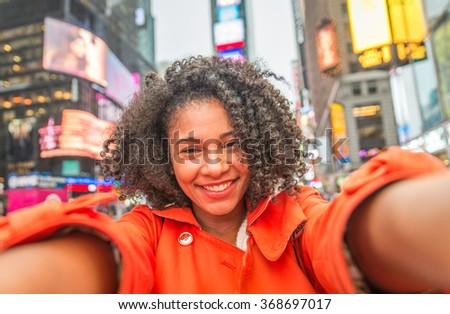 Happy afroamerican woman taking selfie in Time square, New york. Traveling in the US and taking nice photos